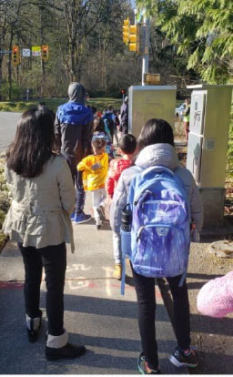 Children waiting in line at school to complete COVID-19 check-in procedures 