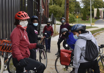 Six cyclists on a sidewalk 